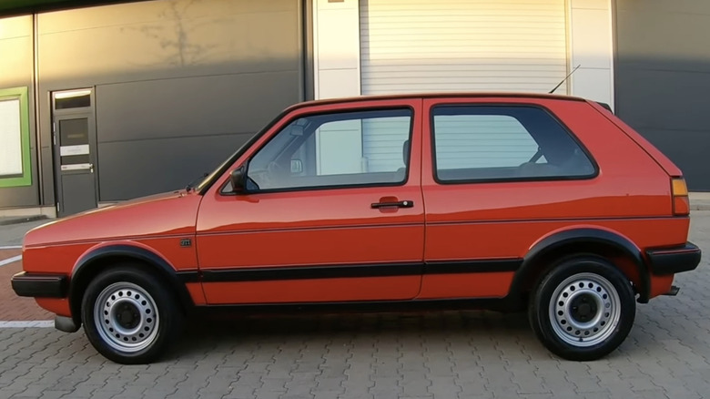 A red Volkswagen Golf GTI Mk2 sits parked.