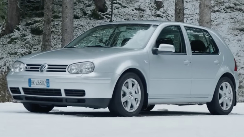 A silver Volkswagen Golf Mk4 sits in snow.