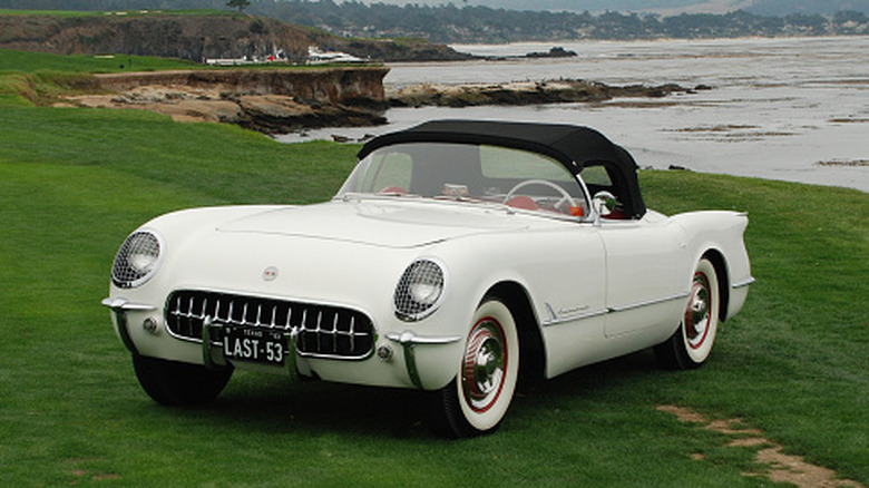 A achromatic 1953 Chevrolet Corvette parked astatine shore.