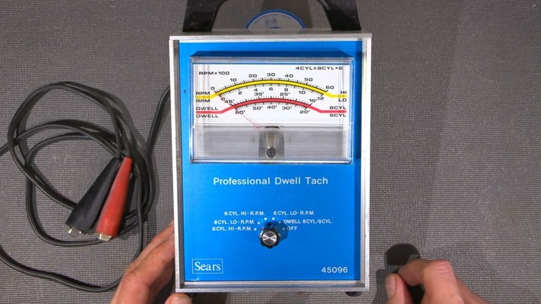 A close-up shot of a vintage blue Sears dwell meter on a gray background