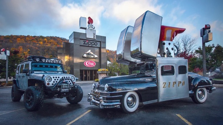 A Zippo car and jeep parked in front of the company's building