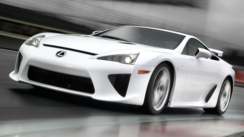 A white Lexus LFA supercar clipping a track apex at high speed