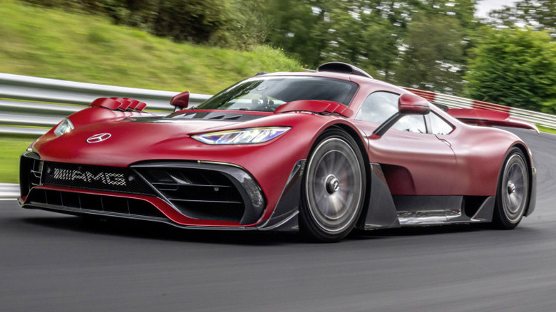 Red Mercedes-AMG ONE hypercar cornering at high speed on track with motion blur