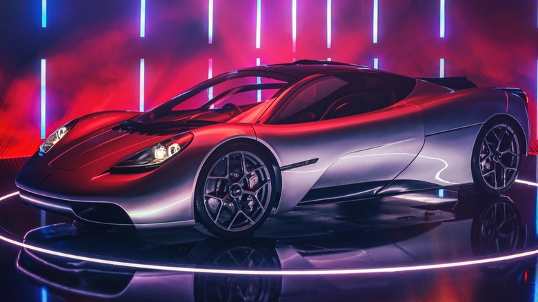 A silver Gordon Murray Automotive T.50 supercar under studio neon lighting