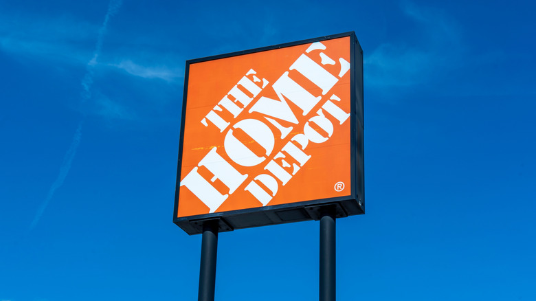 An orange sign for The Home Depot beckons automotive enthusiasts against a blue sky.