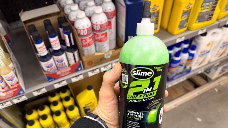 Container of Slime tire sealant held in hand.