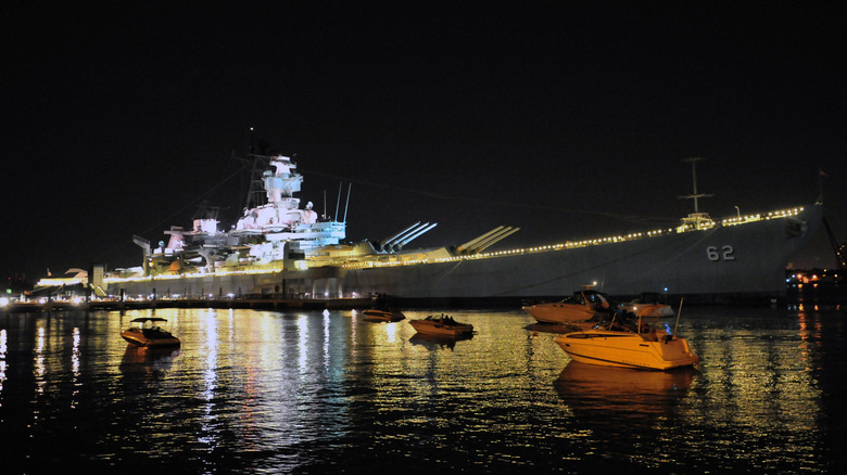 Battleship USS New Jersey seen at night from starboard at her berth in Camden, New Jersey, decorated with lights