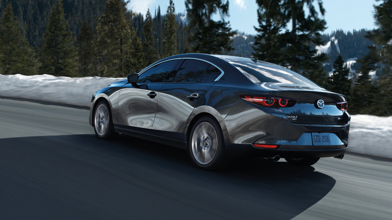 Rear 3/4 view of a gray 2026 Mazda 3 sedan.