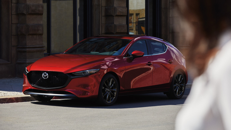 Front 3/4 view of a red 2026 Mazda 3 hatchback.