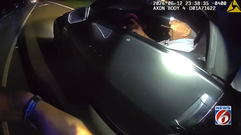 A screenshot of the body cam footage from Bosworth's traffic stop, as he sits in his 2006 Nissan 350Z smoking a cigar and speaking with authorities.
