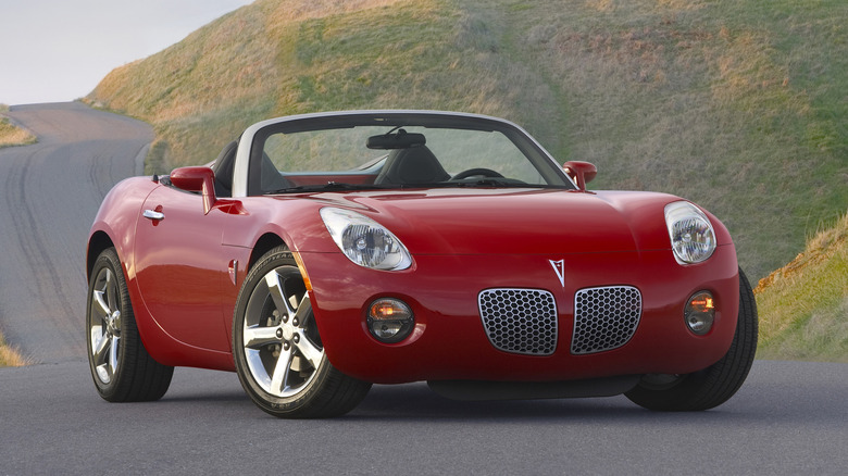 Front three-quarter image of a red Pontiac Solstice convertible.