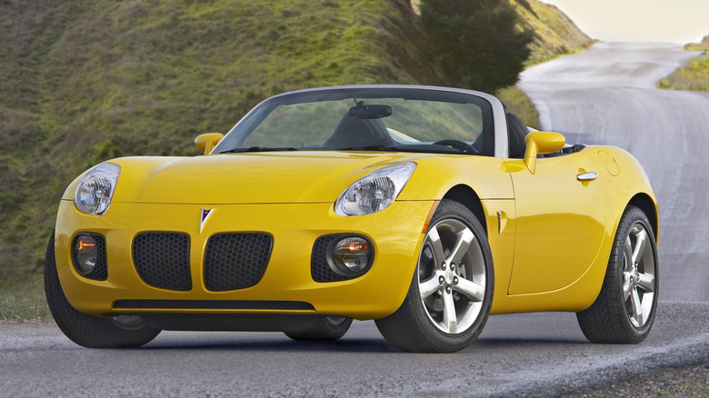 Press photo of a yellow Pontiac Solstice convertible, three-quarter view.