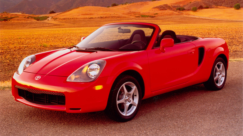 Press image of a red 2000 Toyota MR2 Spyder against a grassy desert background.