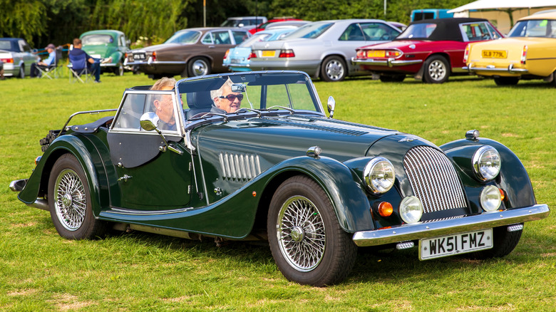 A green Morgan Plus 8 pictured at a car event on grass.