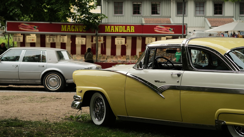 American car parked outside of a Swedish restaurant.