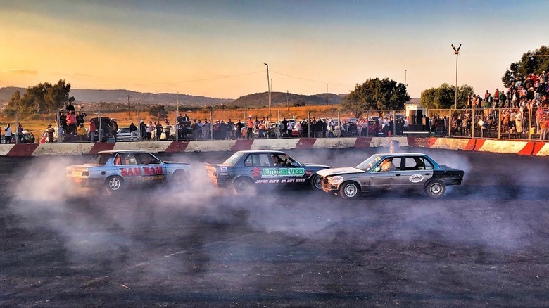 Wide shot of three South African Spinner cars doing donuts.