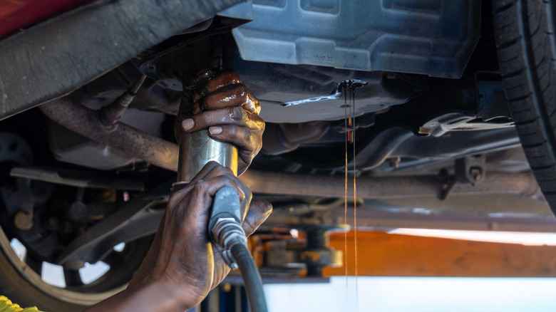A mechanic does a transmission fluid change.