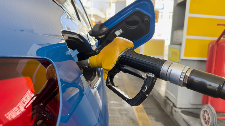 A fuel nozzle is filling up a car.