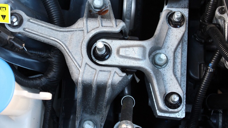 A close-up shows an engine mount.