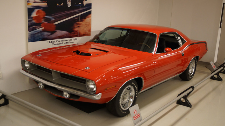 Red Plymouth Hemi Cuda displayed in a museum.