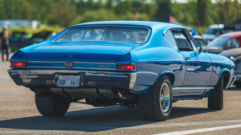 Rear 3 quarters of a bluish Chevy Chevelle astatine a car show