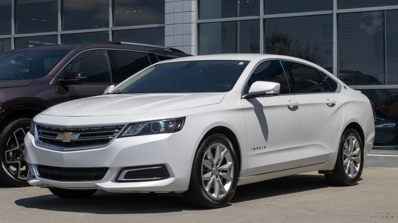 White Chevrolet Impala sedan parked connected a dealership lot