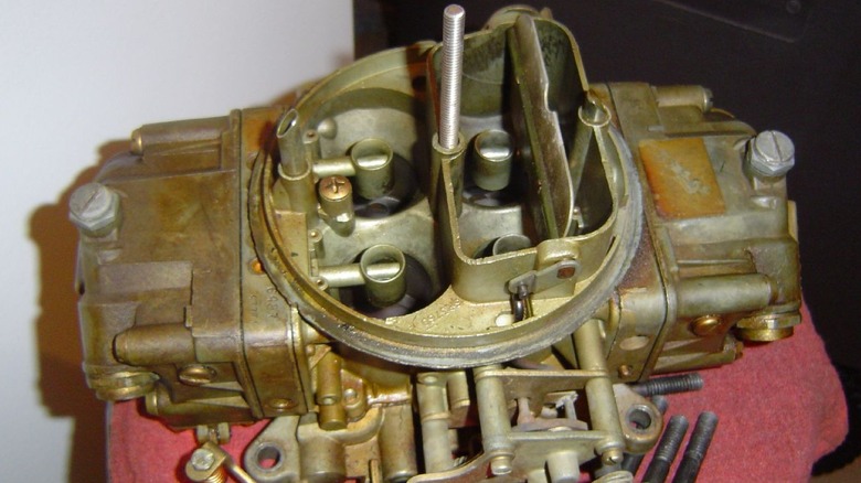 Holley 460 double pumper carburetor on display on its own, not attached to any engine.