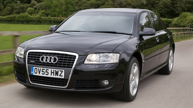 A black Audi A8 cruises through the countryside.