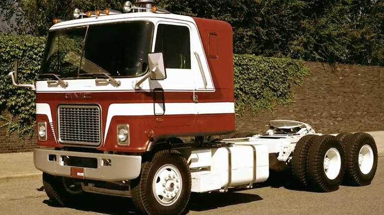 A red GMC Astro sits parked.