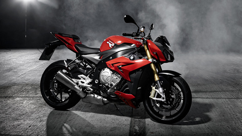 A red 2014 BMW S1000R at night with smoke drifting behind it.
