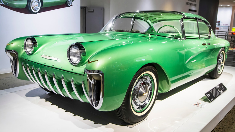 A rare 1955 Chevrolet Biscayne XP-3 concept car in vibrant green with futuristic styling, unique headlights, and chrome details, displayed in a museum.