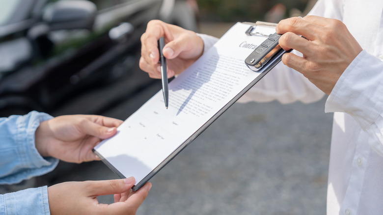 Paperwork is shared on a clipboard.