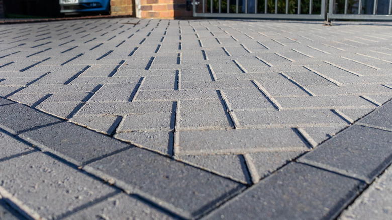 A very flat brick driveway is photographed up close.