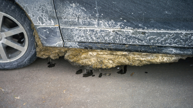 A buildup of ice and salt residue is shown on the underside of a car.