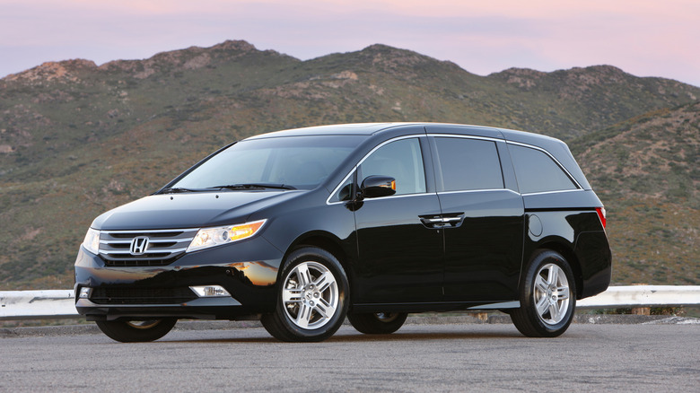 A black Honda Odyssey is parked in the mountains.