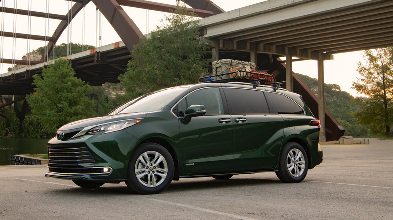 A Toyota Sienna sits parked near a bridge.