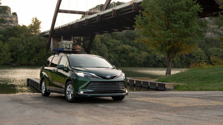 A Toyota Sienna sits parked near a river.
