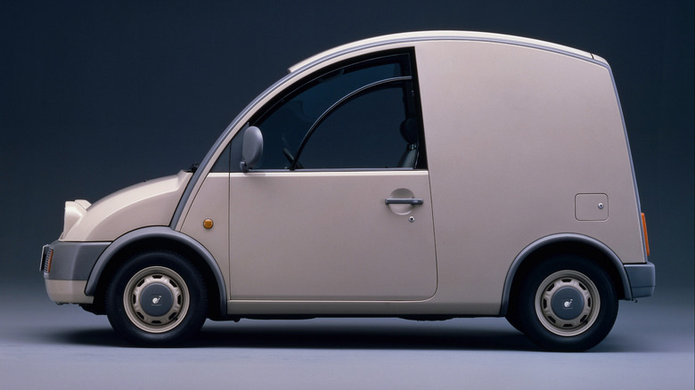 A factory studio shot of a beige Nissan S-Cargo retro van parked in a studio.