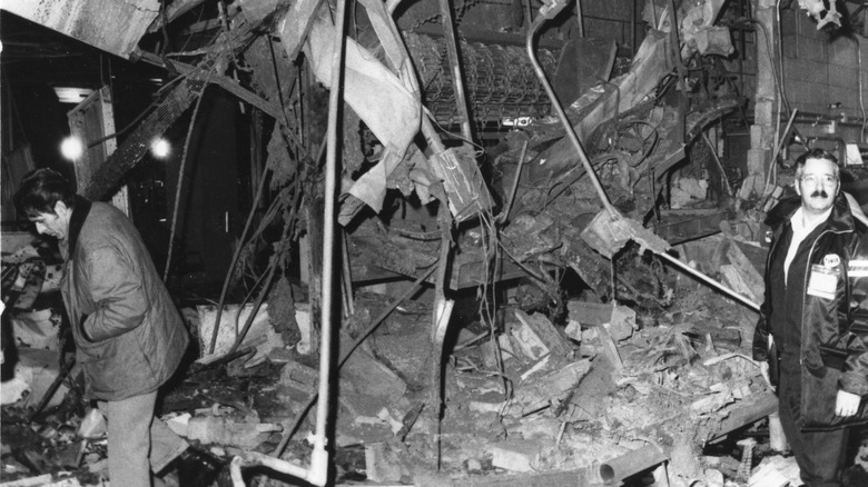 Two unidentified men examine bomb damage near a locker area in the baggage reclaim terminal at LaGuardia Airport, New York, New York, December 29, 1975. The bomb killed 11 people and injured more than 70 others.