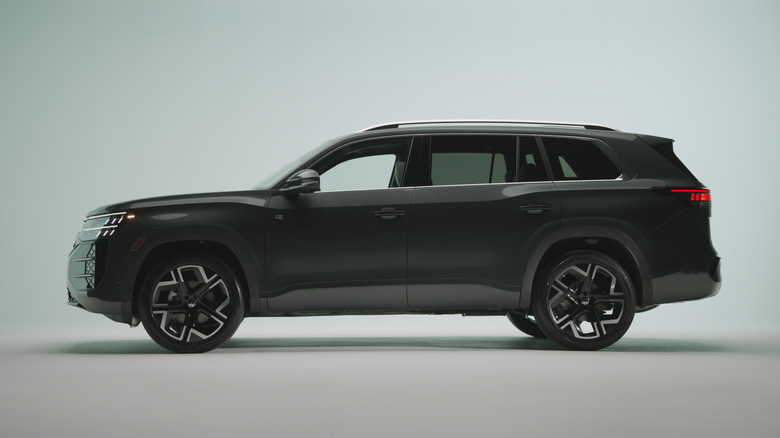 A driver's-side profile shot of a black 2027 Volkswagen Atlas in a studio setting