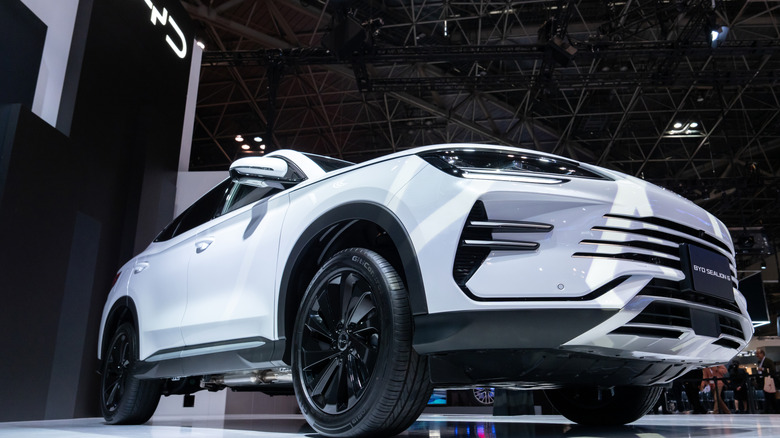 a hero shot of a white BYD SUV at an auto show