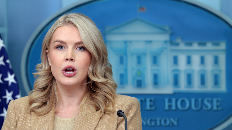 White house press secretary Karoline Leavitt standing at a podium with the seal of the White House behind her