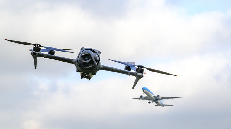 A drone flies near Schiphol Airport in the Netherlands as a plane takes off