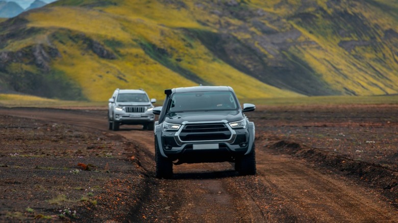 Two SUVs driving on off-road trail