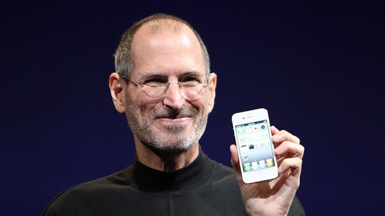 Steve Jobs holding up an early generation iPhone at an Apple convention