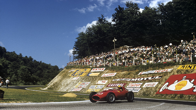 A race car positioned in front of advertising at the Rouen-les-Essarts French Grand Prix.