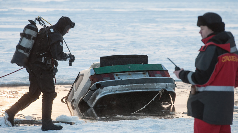 A car being pulled out of a river during winter