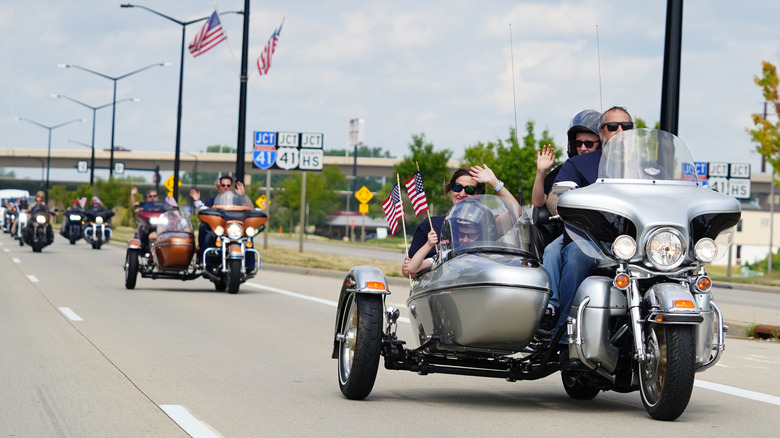 A row of Harley-Davidson touring motorcycles with sidecars in a parade.