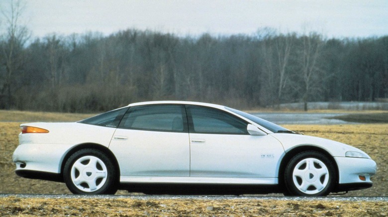The profile of the 1990 Eagle Optima concept parked outside in front of trees