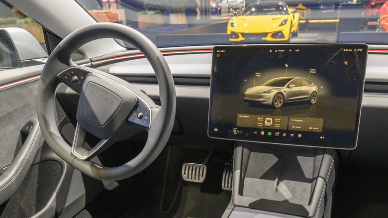 The interior of a 2025 Tesla Model 3 with standard steering wheel turn signal buttons